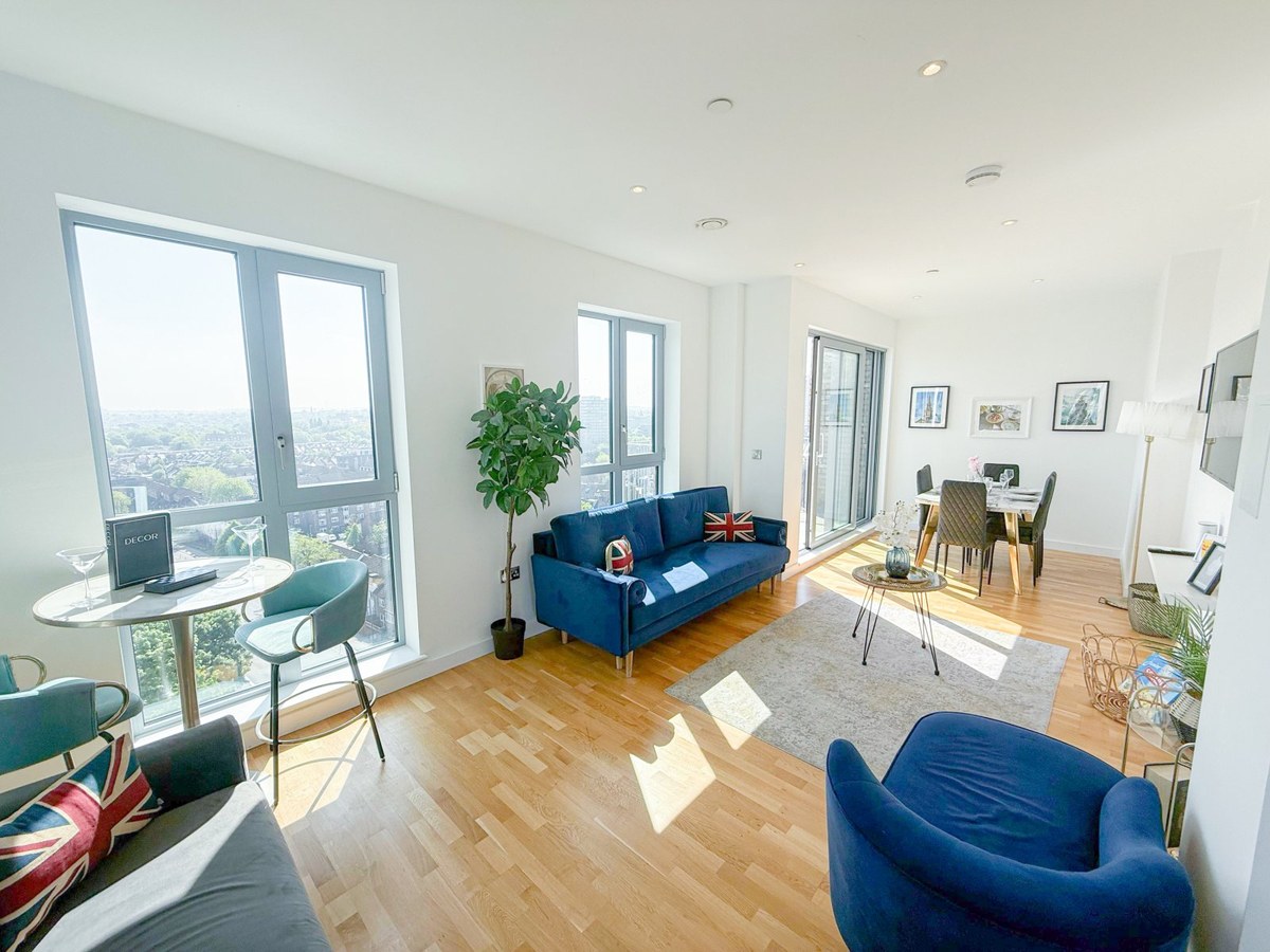 Living and dining room with blue seating and large windows
