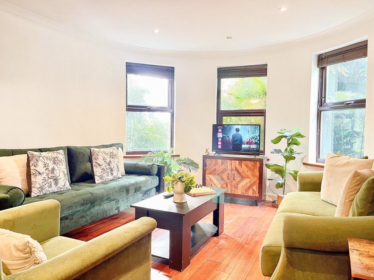 Living room with green sofas, a coffee table and television