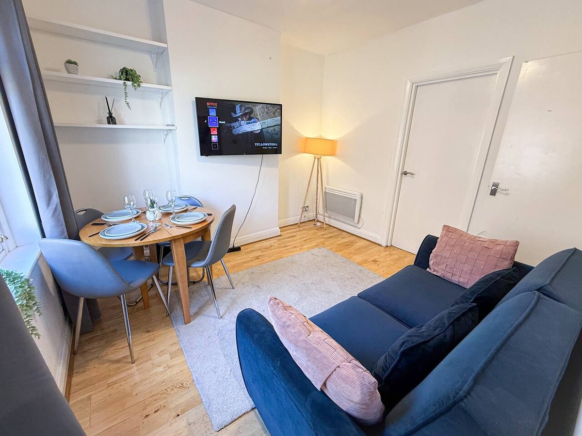 Living room with a sofa and dining table in Hackney